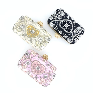 Close-up of heart-shaped beaded evening clutches with pearls, rhinestones and sequins