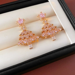 Detail of rose gold Christmas tree earrings with pink and white cubic zirconia in a box