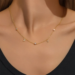 Detailed view of gold S925 sterling silver star and moon necklace on a female model