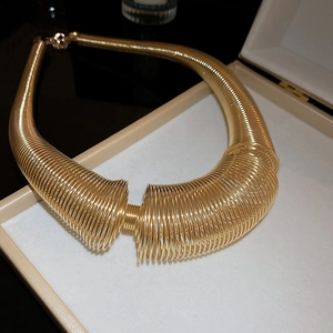 Statement gold layered spring coil necklace displayed in a premium jewelry gift box