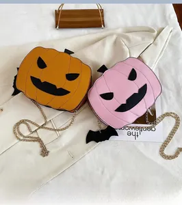 Detail of pumpkin crossbody bags in orange and pink with chain straps and bat decor