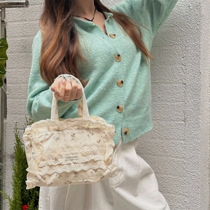 Vue détaillée du sac cabas en toile à fleurs avec bordures en dentelle et style rétro