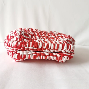 Macro shot of the thick red and white striped crochet texture on a handmade cloud bag