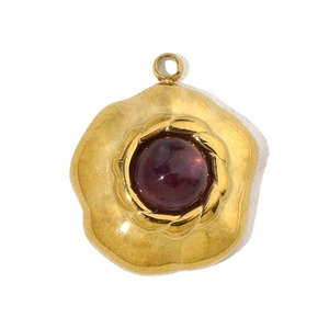 Detailed macro view of a gold-tone floral charm with a round purple translucent stone