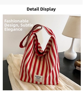 Detail of red and white striped canvas tote bag with stitched letter logo patch