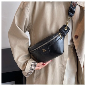 Detail of black wax leather chest bag with gold zipper and patterned woven strap