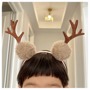 Close-up of a child wearing a plush reindeer antler headband for Christmas festivities