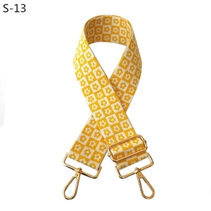 Detail of yellow and white checkerboard floral woven strap with golden metal buckles