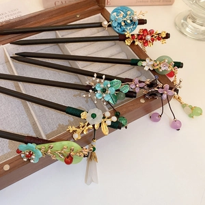 Detailed view of vintage wood hairpins with floral resin, pearls and beaded tassels