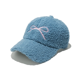 Detailed shot of blue teddy fleece baseball cap with pink embroidered bow decoration