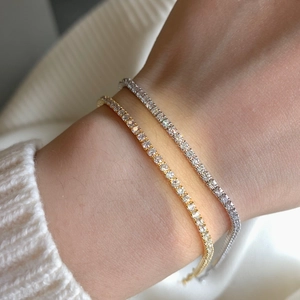 Close-up of gold and silver S925 tennis bracelets with clover geometric zircon studs