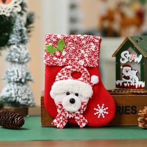 Detail of red knit Christmas stocking featuring a 3D teddy bear and snowflake embroidery