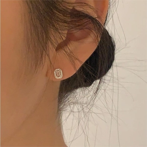 Macro shot of a classic square halo stud earring with cubic zirconia on model ear