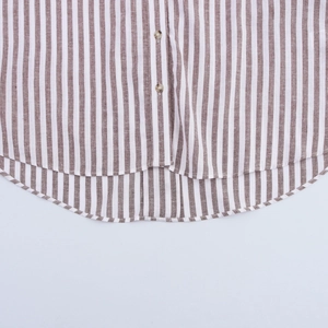 Détail de l'ourlet incurvé et des boutons sur la chemise à rayures marron et blanc