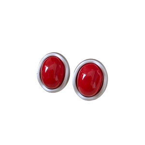 Elegant oval red resin gemstone earrings with minimalist silver metal bezels on white background