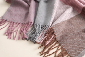 Close-up of fringe details on pink, grey and brown color-blocked plaid winter scarf