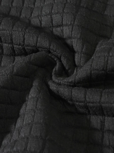 Macro shot of black waffle knit fabric showing premium texture and fiber detail