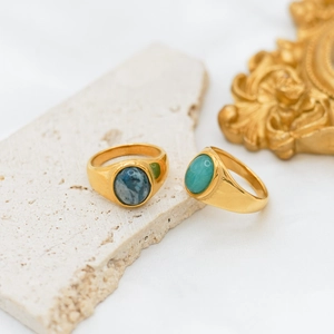 Detail of vintage 18k gold plated titanium rings with oval blue and green agate stones