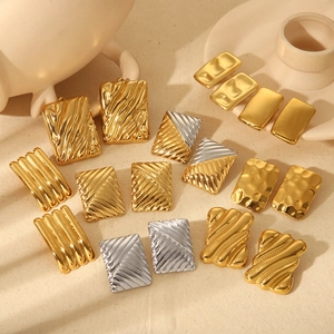 Textured square wave earrings in gold and silver finish on a minimalist background
