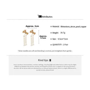 Detailed view of silver needle bow earrings with zircons, pearls and long tassels