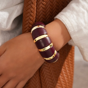 Chunky purple acrylic and gold metal elastic bracelet worn on wrist for a boho look