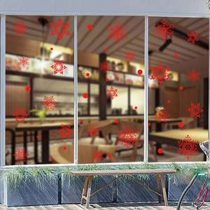Red snowflake window decals applied to a glass window for festive Christmas home decoration