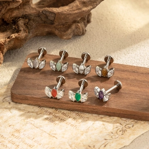 G23 titanium labret studs with marquise colorful zircon stones on a rustic wood stand