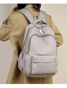Gray fashion backpack for students with multiple pockets and white zipper pulls