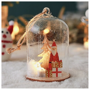 Detail of a Christmas glass globe with warm LED lights and a miniature tree scene