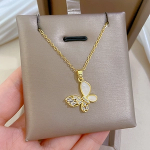 Detail of a gold butterfly necklace with zircon stones held in a premium jewelry box