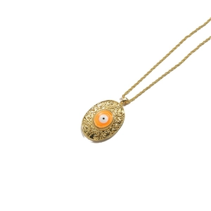 Vintage gold oval pendant necklace featuring orange evil eye motif on twisted chain