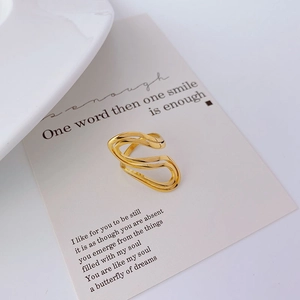 Minimalist gold wave open ring in polished stainless steel on a vintage poem card