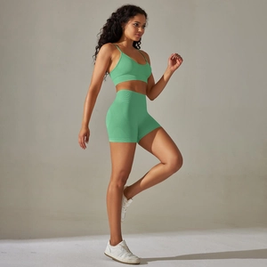 Detail of green seamless knit sports set featuring V-neck bra and high waist shorts