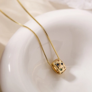18K gold plated geometric cube necklace with colorful zircon stones on a white ceramic tray