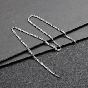 Detailed close-up of a silver wheat chain necklace featuring a secure lobster clasp