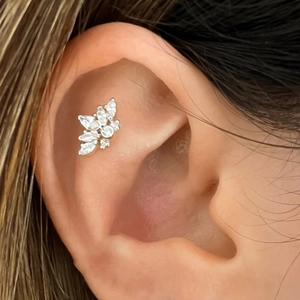 Close-up of sparkling heart and butterfly flat back cartilage studs with chain on ear
