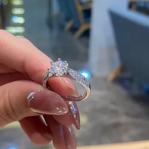 Close-up of the six-prong set round brilliant diamond and pavé band on silver ring