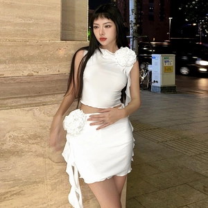 Detail of white two-piece set featuring large 3D floral accents on shoulder and waist