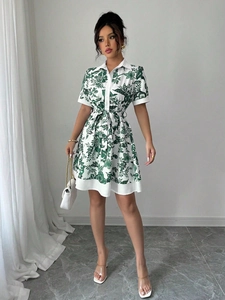 Detail of green and white floral print shirt dress with button-up front and drawstring waist