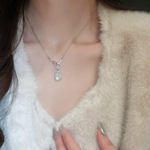 Detail showing a silver gourd pendant with sparkling zircon on a model's neck