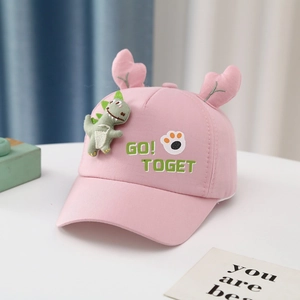 Detailed side view of pink cotton baby cap with 3D dinosaur and deer antler decorations