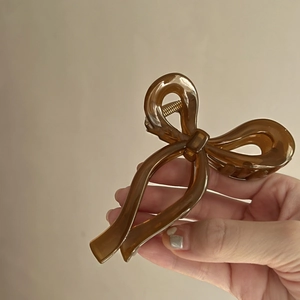 Close-up of amber butterfly hair claw clip with metallic spring and glossy finish