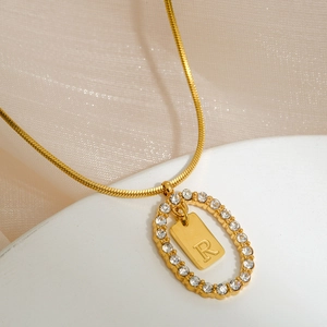 Detail of gold letter R pendant with sparkling rhinestones and delicate snake chain