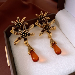 Detail of vintage gold flower earrings with amber teardrop pendants in a gift box