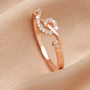 Macro shot of rose gold treble clef ring with sparkling white pavé-set crystals