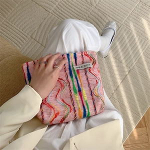 Close-up of rainbow striped knit canvas tote bag with woven texture and Korean label