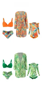 Flat lay of tropical floral bikini sets and long-sleeved cover-ups in orange and green