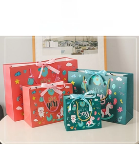 Detail of pink and blue gift bags with satin ribbons and cute cartoon bear prints