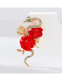 Macro detail of gold snake brooch with sparkling crystals and vivid red rose flowers