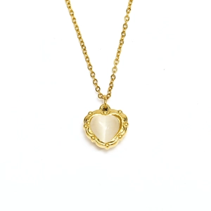 Detail of vintage heart pendant with milky gemstone and 18k gold plated border